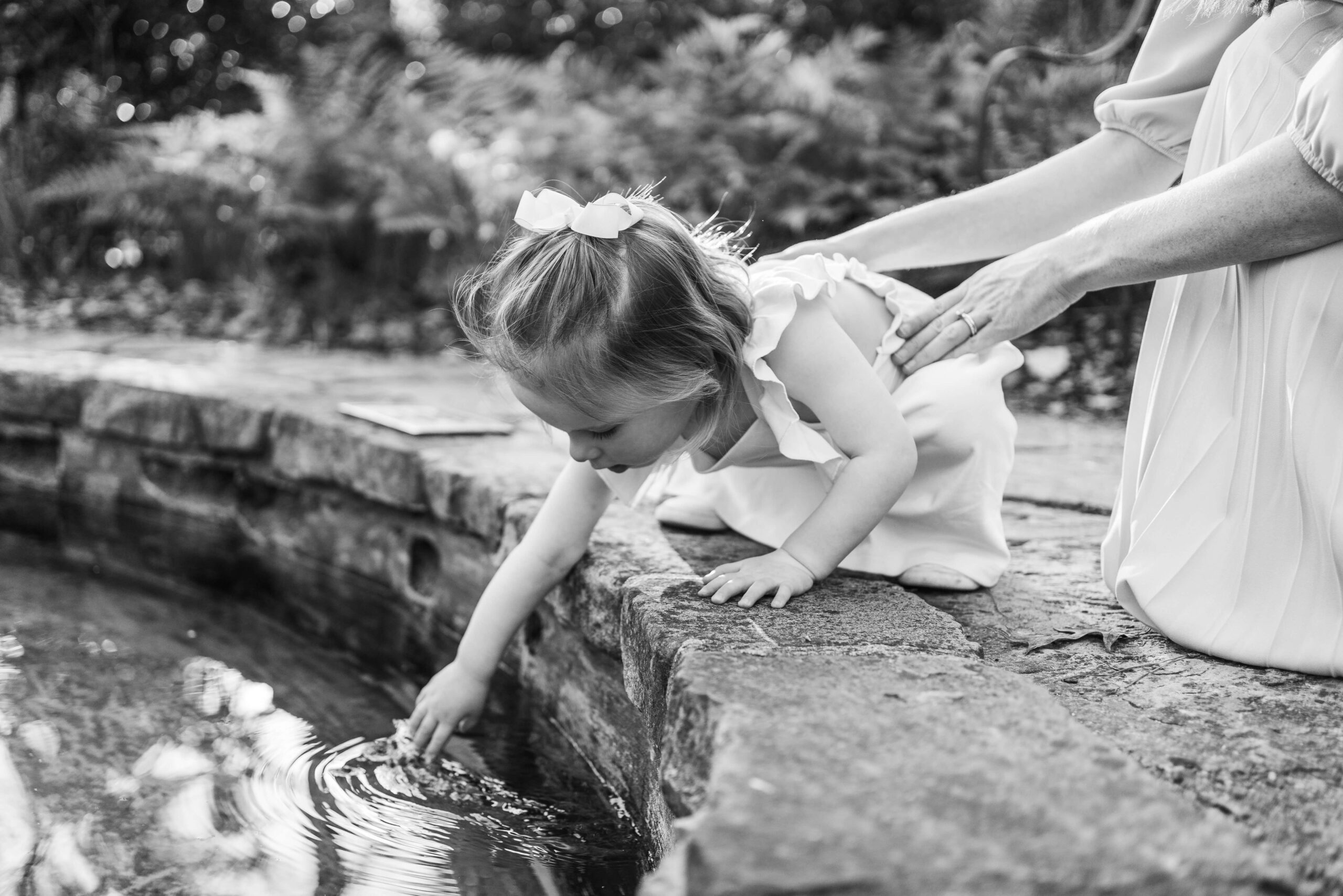 Girl brushing water at Birmingham Botanical Gardens on things to in Birmingham with kids.