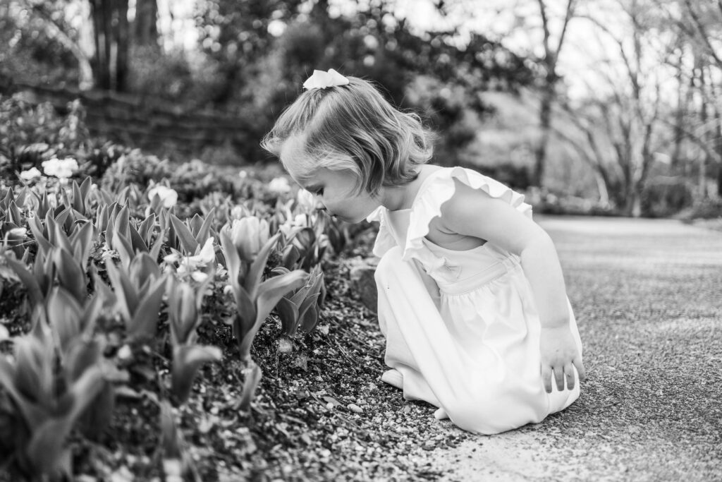 Girl smelling flower at Birmingham Botanical Gardens on things to do in Birmingham with kids.