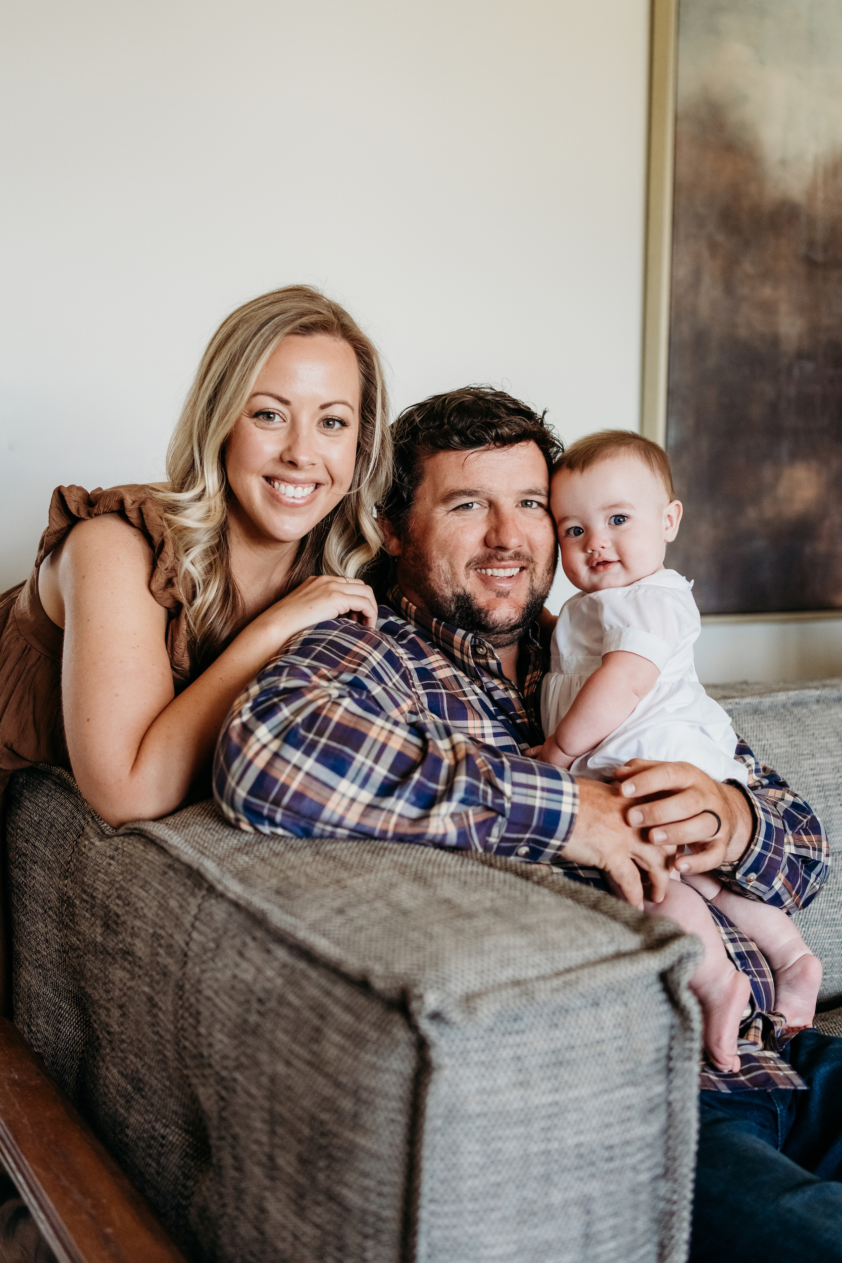 Photo of mom, dad, and baby smiling.