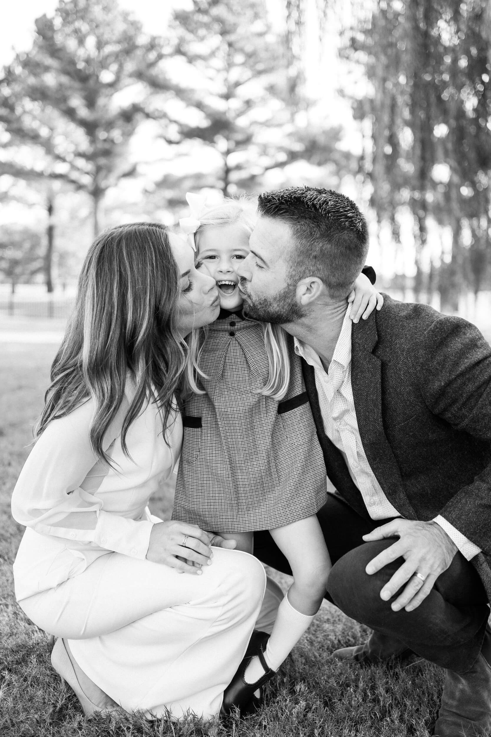 Family kisses outside on a warm fall day after visiting Child's Play Therapy Center