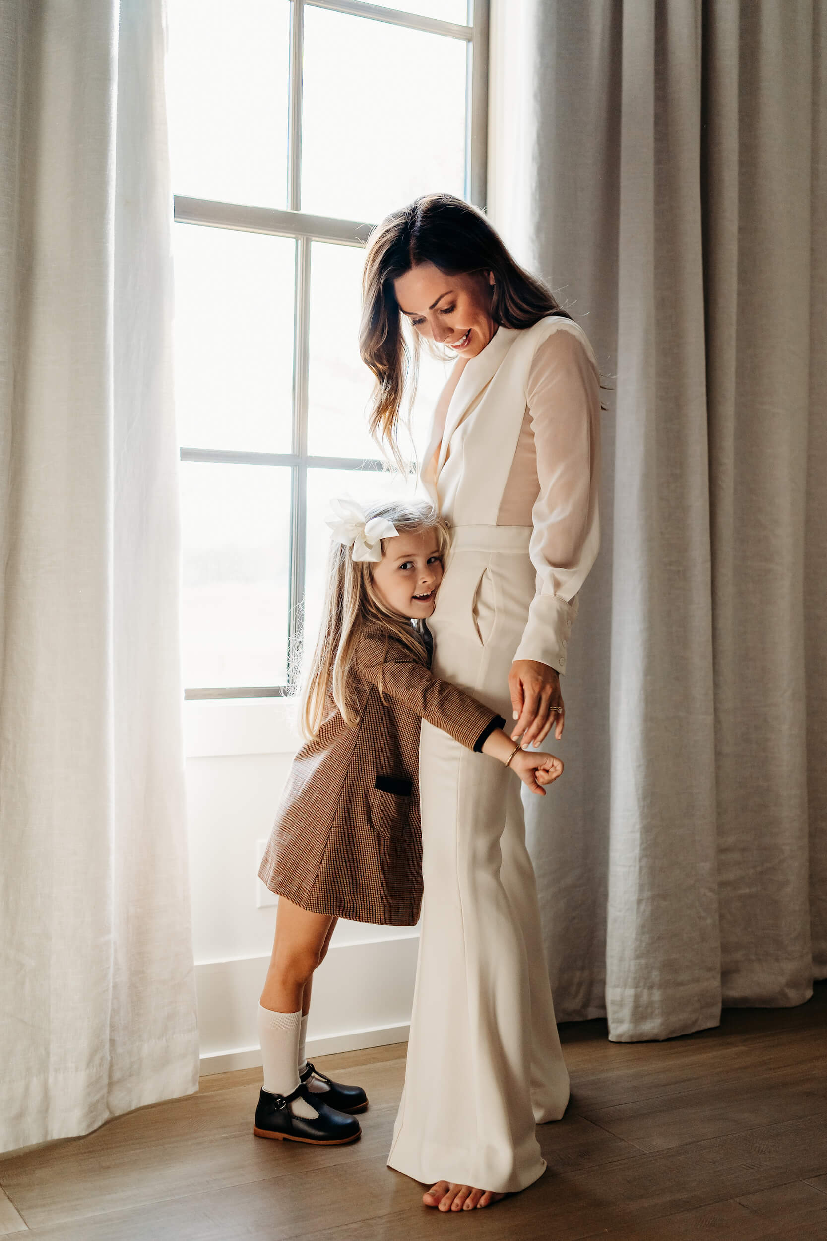 Girl hugging mom in front of the window after visiting Child's Play Therapy Center